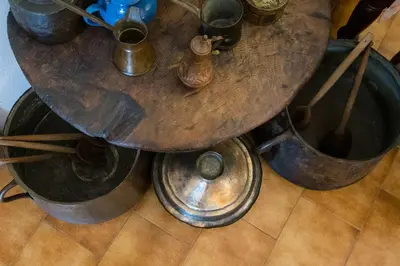 a wooden table with metal pots on a floor at Traditional Family Cretan Home! in Yerakianá