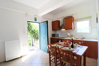 a kitchen and dining room with a table and chairs at Kalimera Apartments in Vamos