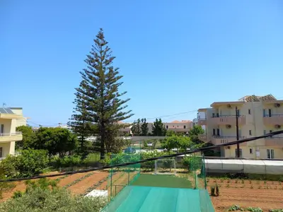 a view of a tennis court with a tree at Litinas Apartments with pool in Agia Marina Nea Kydonias