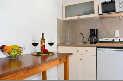 a kitchen with a counter with two glasses of wine at Litinas Apartments with pool in Agia Marina Nea Kydonias