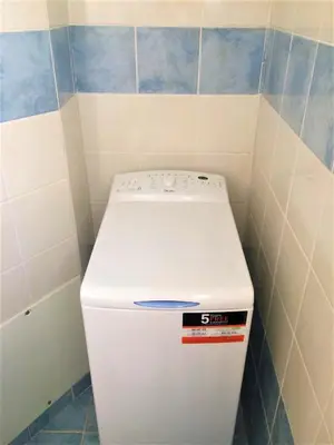a white refrigerator in a corner of a bathroom at Sweet Home Lena Feel like home in Chania Town
