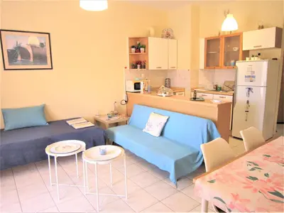 a living room with a couch and a kitchen at Sweet Home Lena Feel like home in Chania Town