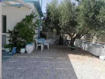 a patio with a table and chairs and trees at Casa D'armaros in Kissamos