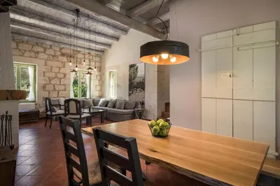 a dining room with a wooden table and chairs at BOUTIQUE VILLA PETRA AMANDA Heated pool optional in Fílippos