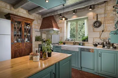 a kitchen with blue cabinets and a wooden counter top at BOUTIQUE VILLA PETRA AMANDA Heated pool optional in Fílippos