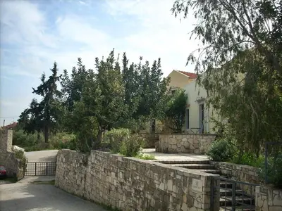 a stone retaining wall in front of a house at Group Accomodation, Heliopetra Studios And Houses in Douliana