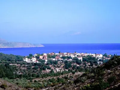 a town on a hill next to the water at Group Accomodation, Heliopetra Studios And Houses in Douliana