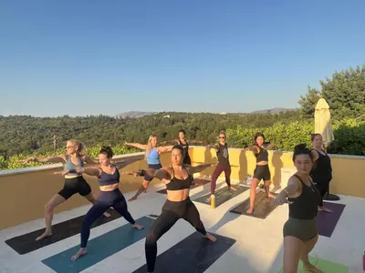 a group of women doing yoga on a roof at Group Accomodation, Heliopetra Studios And Houses in Douliana