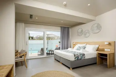 a bedroom with a bed and a view of the ocean at Sarpidon Suites in Agia Marina Nea Kydonias