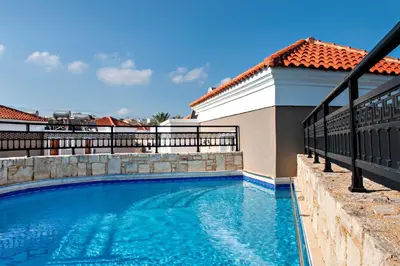 a swimming pool in front of a house at Alexandra Beach Hotel in Agia Marina Nea Kydonias