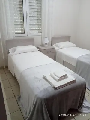 a bedroom with two beds with towels on a table at Voula's Place in Chania Town