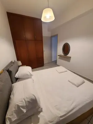 a bedroom with a large white bed and a mirror at Voula's Place in Chania Town