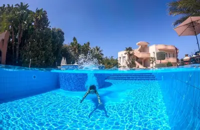 a person is in the water in a swimming pool at Villa Elina Luxury Residence in Stalos