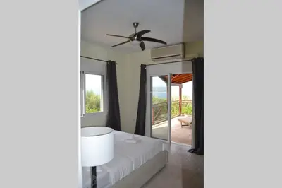 a bedroom with a bed and a ceiling fan at Villa Melpomeni in Sinoikismós Plakálona