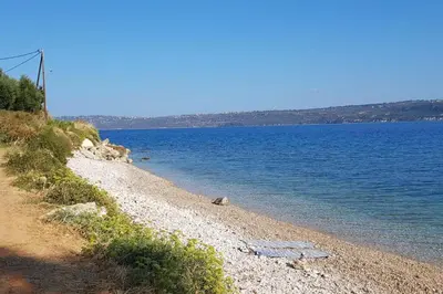 a rocky beach with a large body of water at Villa Melpomeni in Sinoikismós Plakálona