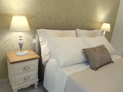 a bed with a lamp on a nightstand next to a bed with a pillow at Meryland in Chania Town