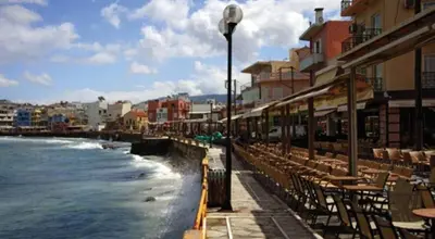 a street with tables and chairs next to the water at Meryland in Chania Town