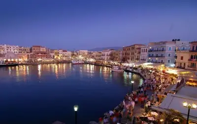 a group of people walking along a river at night at Meryland in Chania Town