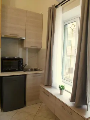 a small kitchen with a microwave and a window at Meryland in Chania Town