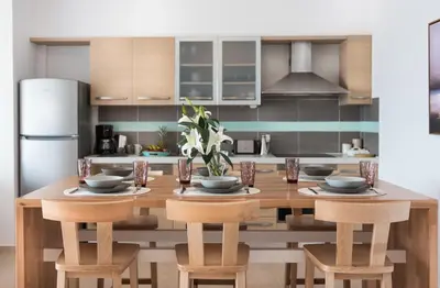 a kitchen with a wooden table with chairs and a refrigerator at Luxury Villa Mystique with Amazing Seaview in Chania Town