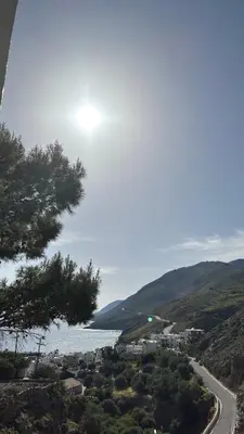 a road next to a body of water at Mesohori studios in Sfakiá