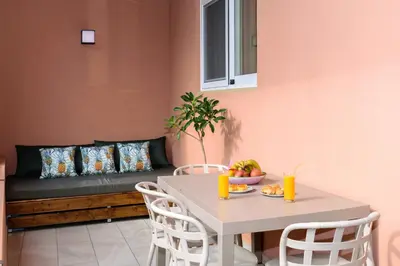 a table and chairs in a living room with a couch at Iliana Apartments in Falasarna