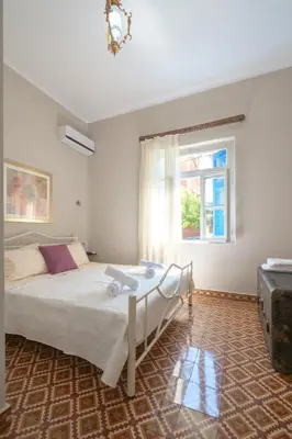 a bedroom with a bed and a window at Grandma's Chic Home in Chania Venetian Harbor in Chania Town