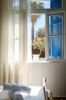 a bedroom with a window with a white curtain and a bed at Grandma's Chic Home in Chania Venetian Harbor in Chania Town