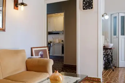 a living room with a chair and a table at Grandma's Chic Home in Chania Venetian Harbor in Chania Town