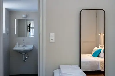 a bathroom with a mirror and a sink and a bed at Grandma's Chic Home in Chania Venetian Harbor in Chania Town