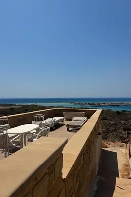 a patio with a table and chairs and the ocean at Elafonisi Villa above the Beach in Elafonisi