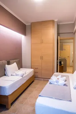 a bedroom with two beds and a cabinet at Semeli Studios in Chania Town