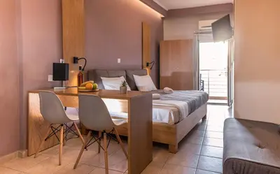 a bedroom with a bed and a table and chairs at Semeli Studios in Chania Town