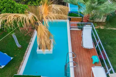 an overhead view of a blue swimming pool with a wooden deck at Chania Green House 2 in Aghii Apostoli
