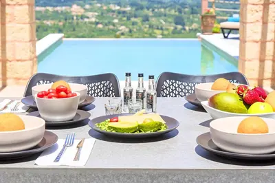 a table with bowls of fruit and plates of food at Villa Vardis Heated Pool in Vryses