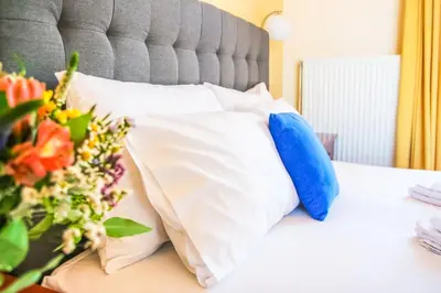 a bed with white and blue pillows and flowers on it at Villa Panagiotis Chania in Daratso
