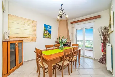 a dining room with a wooden table and chairs at Villa Panagiotis Chania in Daratso