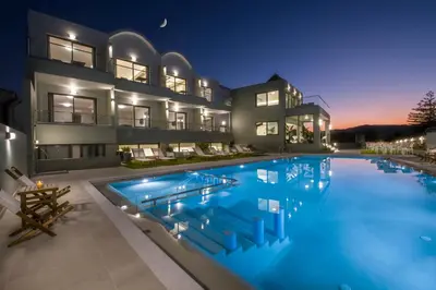 a large swimming pool in front of a house at night at Incognito Creta Luxury Suites and More in Kolymvari