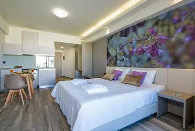 a bedroom with a large white bed with purple pillows at Incognito Creta Luxury Suites and More in Kolymvari
