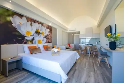 a bedroom with a large bed with a painting on the wall at Incognito Creta Luxury Suites and More in Kolymvari