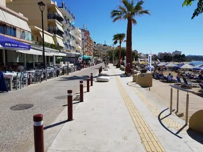 a street with chairs and palm trees on a beach at Palm Luxury Studios in Chania Town