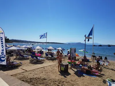 a group of people on a beach with the water at Palm Luxury Studios in Chania Town