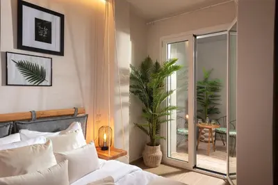 a bedroom with a bed and a sliding glass door at Palm Luxury Studios in Chania Town