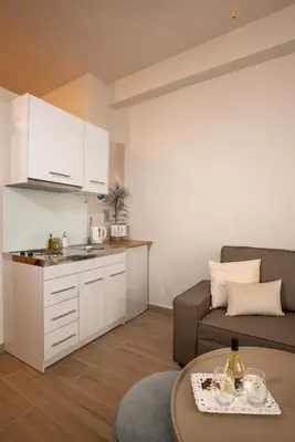 a kitchen and a living room with a couch and a table at Palm Luxury Studios in Chania Town