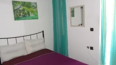 a bedroom with a bed and a mirror at Summer Holidays Studio in Chania Town