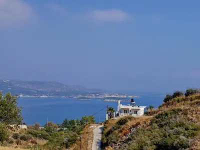 a house on a hill next to a body of water at Villa Nikos Megala Chorafia Crete in Áptera