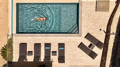 a man is swimming in a swimming pool at Villa Nikos Megala Chorafia Crete in Áptera