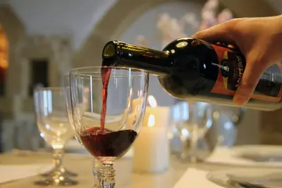 a person pouring red wine into a wine glass at Charming villa in Chania with parking included in Kolymvari