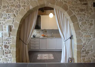 a kitchen with an archway in a stone wall at Charming villa in Chania with parking included in Kolymvari