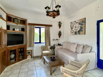 a living room with a couch and a tv at Maros Spitaki in Varípetron